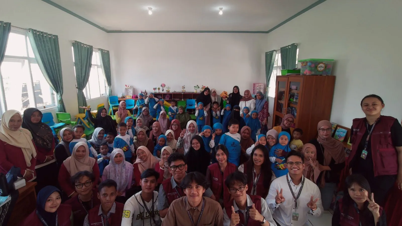 Tim KKN T2 berfoto bersama kepala sekolah, guru, wali murid, dan murid TK Negeri At-Taqwa Silebu “Cantik” di dalam ruang kelas.