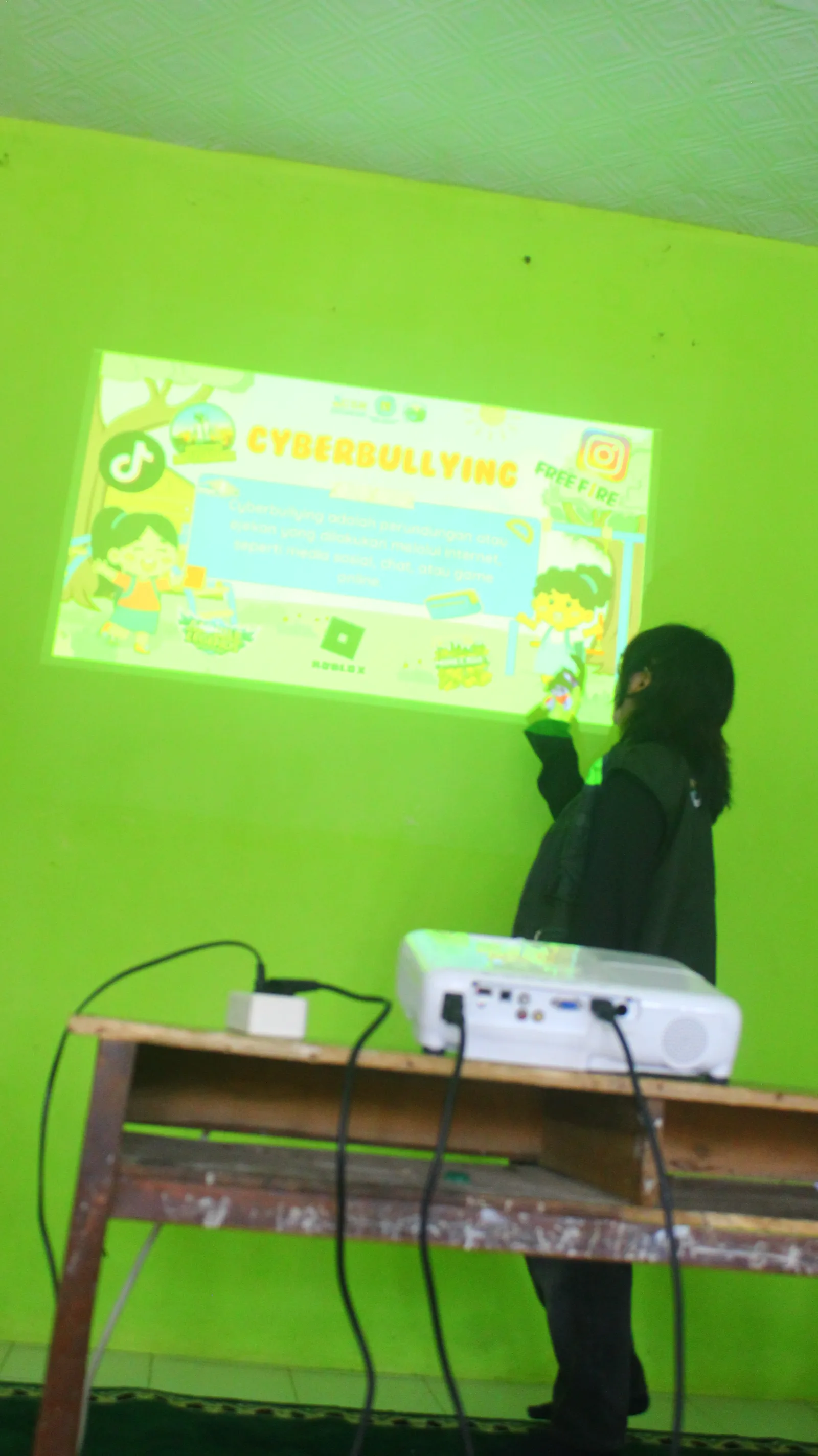 Mahasiswa KKN T3 memaparkan pengertian cyberbullying menggunakan materi presentasi.