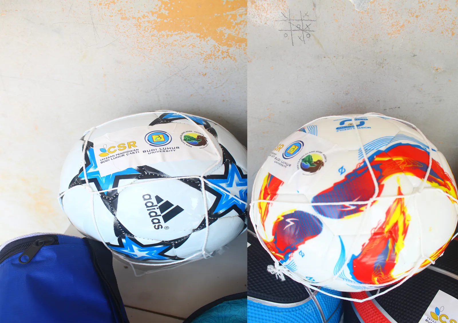 Dua bola sepak bercorak biru dan merah berlabel CSR diletakkan berdampingan.