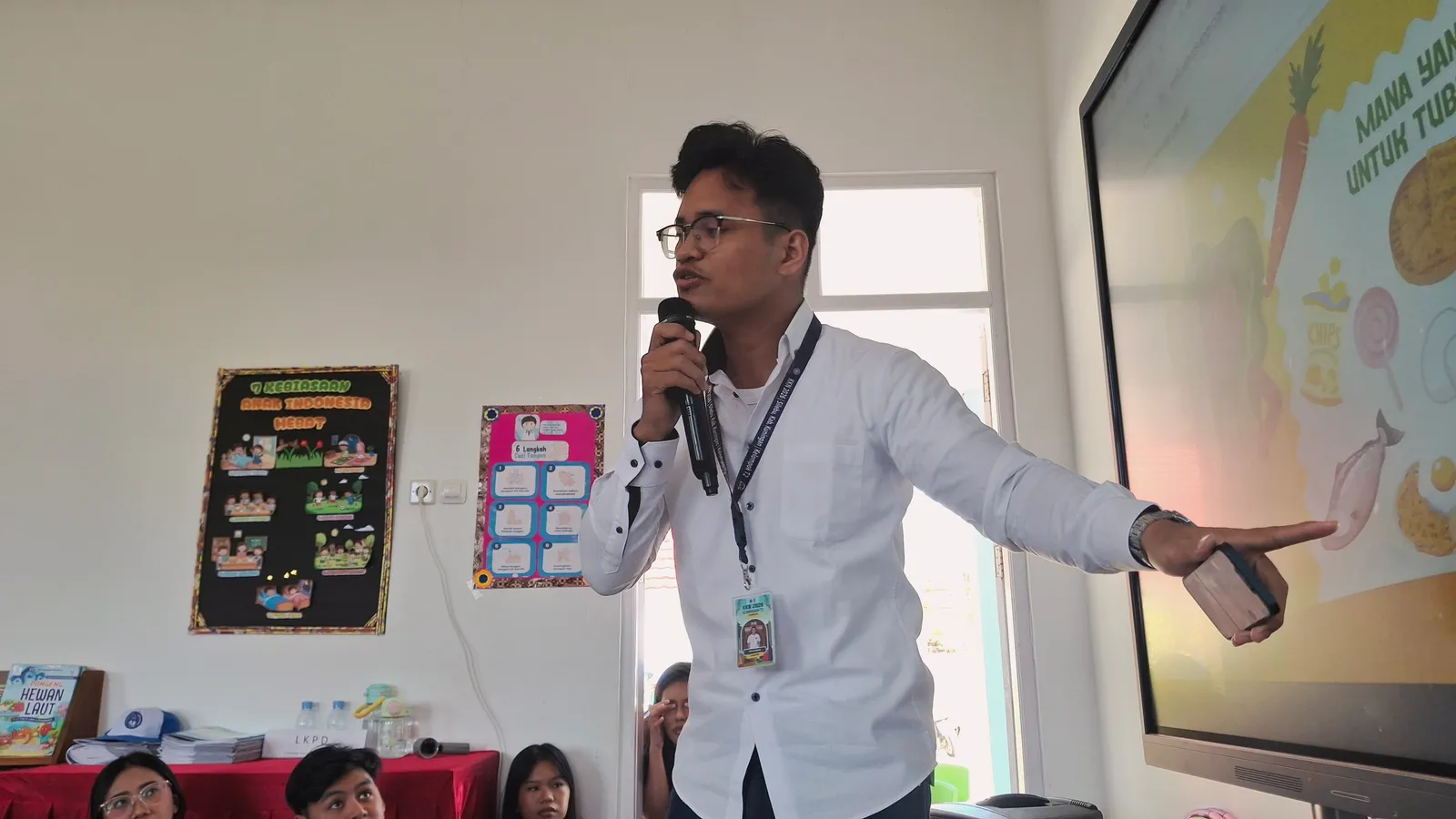 Anggota Tim KKN T2 menyampaikan materi edukasi gizi ceria menggunakan mikrofon di TK Negeri At-Taqwa Silebu “Cantik”.
