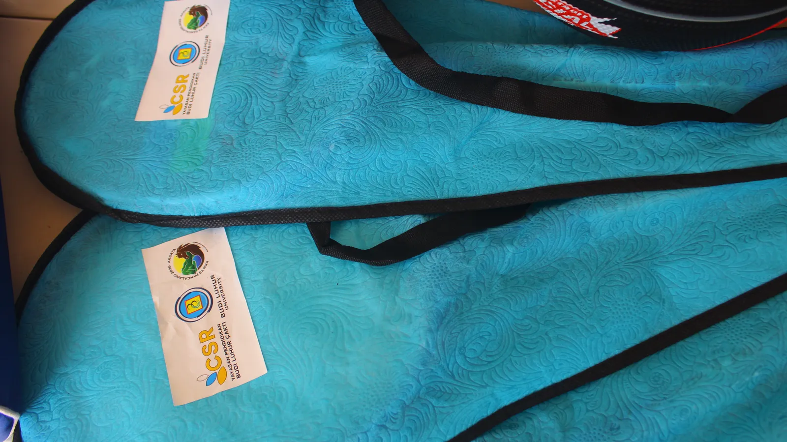 Beberapa tas raket berwarna biru muda dan berlabel CSR diletakkan berdampingan.