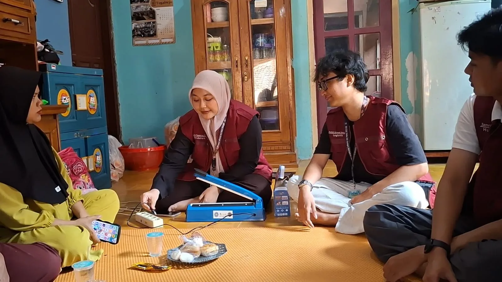 Simulasi dan demonstrasi langsung teknik penggunaan alat pres plastik (impulse sealer) untuk pengemasan produk.