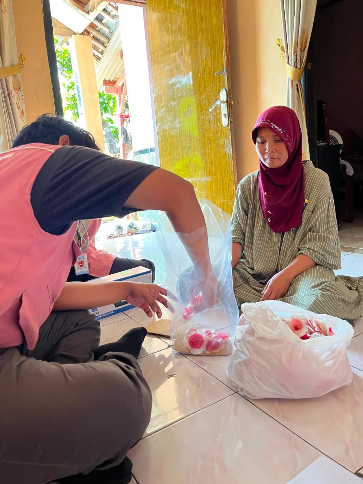 Anggota Tim KKN T1 mendampingi pelaku UMKM saat menata produk ke dalam kemasan plastik.