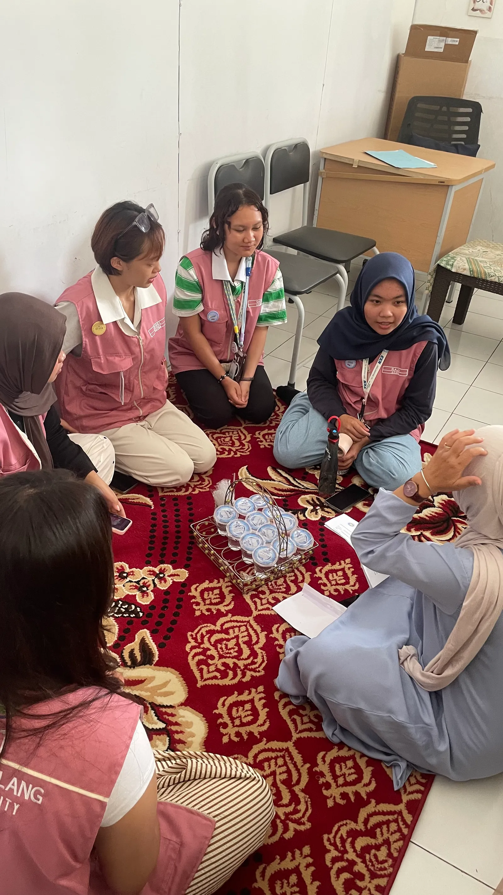 Mahasiswa KKN T1 dan guru TK Al-Hidayah duduk melingkar saat briefing sebelum kegiatan.